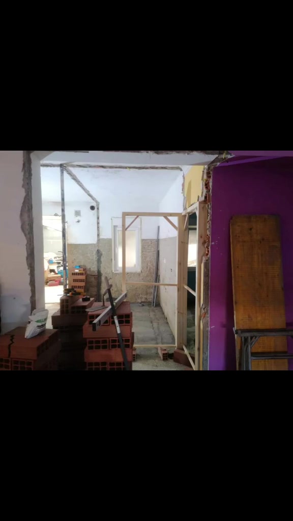 Espacios interiores durante la obra, con materiales de albañilería y un marco a la vista.