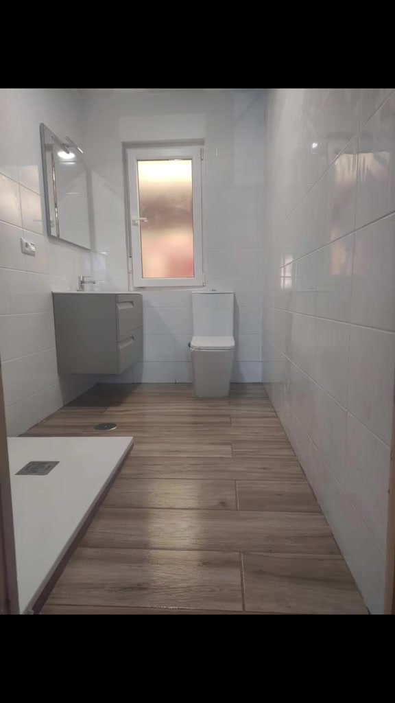 Baño terminado después de una obra de albañilería y reforma de vivienda