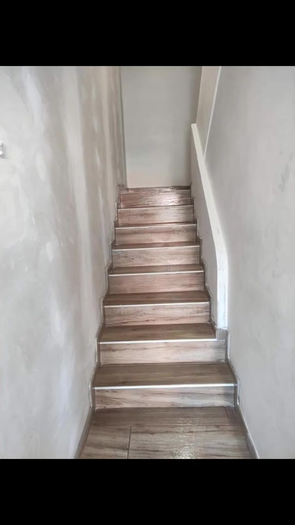 Escalera con pavimento y perfiles en los peldaños, junto a paredes que todavía muestran repasos.