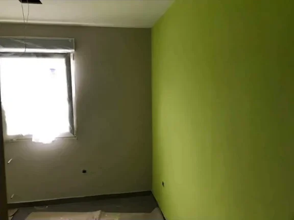 Paredes de una habitación terminadas en blanco y verde tras el tratamiento de base y la pintura anticondensación